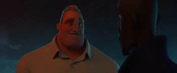 Movie still from “Incredibles 2” (2018), directed by Brad Bird – A man is looking at another man in a dark room; Close Up shot, Over the shoulder angle