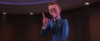 Movie still from “Incredibles 2” (2018), directed by Brad Bird – A man in a suit and tie pointing to his head; Close Up shot, Over the shoulder angle