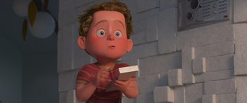 Movie still from “Incredibles 2” (2018), directed by Brad Bird – A cartoon boy holding a box in his hands; Medium shot, High angle