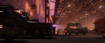Movie still from “Incredibles 2” (2018), directed by Brad Bird – Cars driving down a street at night with a bridge in the background; Wide shot, Low angle