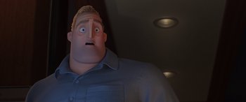 Movie still from “Incredibles 2” (2018), directed by Brad Bird – A man with a surprised look on his face standing in a dark room; Close Up shot, Low angle