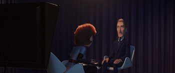 Movie still from “Incredibles 2” (2018), directed by Brad Bird – An animated person sitting in front of a man in a suit; Medium shot, Over the shoulder angle