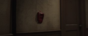 Movie still from “Incredibles 2” (2018), directed by Brad Bird – An old fashioned red telephone hanging on a wall; Medium shot, High angle