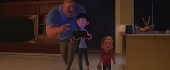 Movie still from “Incredibles 2” (2018), directed by Brad Bird – A man and a woman and a boy are standing in a room; Medium shot, Over the shoulder angle