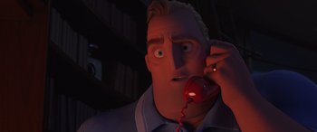 Movie still from “Incredibles 2” (2018), directed by Brad Bird – An animated man is holding a red phone; Close Up shot, Low angle
