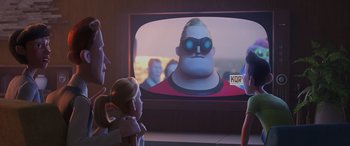 Movie still from “Incredibles 2” (2018), directed by Brad Bird – A group of people standing in front of a television; Medium shot, Over the shoulder angle