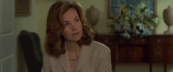 Movie still from “Independence Day” (1996), directed by Roland Emmerich – A person sitting in a chair wearing a suit; Close Up shot, Over the shoulder angle