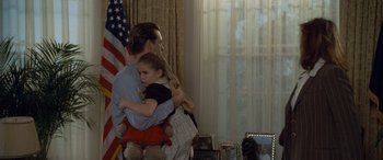 Movie still from “Independence Day” (1996), directed by Roland Emmerich – A man and a little girl hugging in a living room; Medium shot, Over the shoulder angle