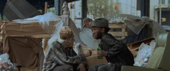 Movie still from “Independence Day” (1996), directed by Roland Emmerich – Two men sitting next to each other holding beer bottles; Medium shot, Over the shoulder angle
