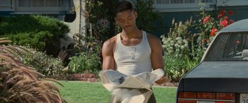 Movie still from “Independence Day” (1996), directed by Roland Emmerich – A man in a white shirt is reading a newspaper; Medium shot, High angle