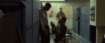 Movie still from “Independence Day” (1996), directed by Roland Emmerich – Two men in a room with lockers; Medium shot, High angle