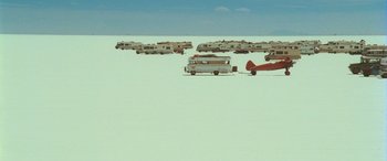 Movie still from “Independence Day” (1996), directed by Roland Emmerich – A group of vehicles parked in the middle of the desert; Extreme Wide shot, High angle