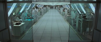 Movie still from “Independence Day” (1996), directed by Roland Emmerich – A group of people standing in a room with trays of food on the floor; Extreme Wide shot, High angle