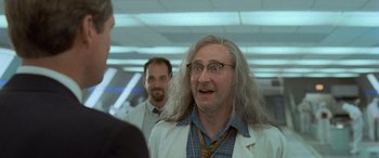 Movie still from “Independence Day” (1996), directed by Roland Emmerich – A group of men standing next to each other in a room; Close Up shot, Over the shoulder angle