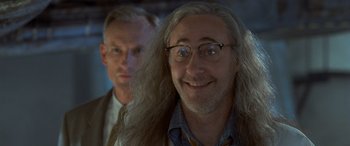 Movie still from “Independence Day” (1996), directed by Roland Emmerich – A man with long white hair and a man with long grey hair; Close Up shot, Over the shoulder angle