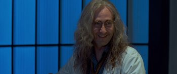 Movie still from “Independence Day” (1996), directed by Roland Emmerich – A man with long hair and glasses smiling for the camera; Close Up shot, Low angle