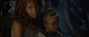 Movie still from “Independence Day” (1996), directed by Roland Emmerich – A woman standing next to a young boy in a hat; Close Up shot, Over the shoulder angle