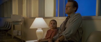 Movie still from “Independence Day” (1996), directed by Roland Emmerich – A man and a little girl sitting next to each other in front of a lamp; Medium shot, Low angle