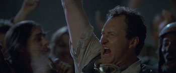 Movie still from “Independence Day” (1996), directed by Roland Emmerich – A man with a tattoo on his arm is yelling; Close Up shot, Low angle