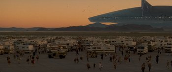 Movie still from “Independence Day” (1996), directed by Roland Emmerich – A group of people standing in a parking lot; Extreme Wide shot, Low angle