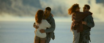 Movie still from “Independence Day” (1996), directed by Roland Emmerich – A man and a woman hugging on the beach; Wide shot, Over the shoulder angle