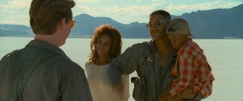 Movie still from “Independence Day” (1996), directed by Roland Emmerich – A man and a woman standing next to each other on a beach; Medium shot, Over the shoulder angle