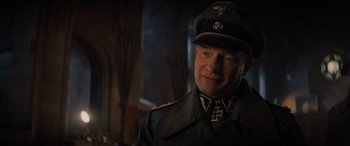 Movie still from “Indiana Jones and the Dial of Destiny” (2023), directed by James Mangold – A man in a military uniform wearing a hat; Close Up shot, Over the shoulder angle