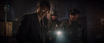Movie still from “Indiana Jones and the Dial of Destiny” (2023), directed by James Mangold – A group of men standing next to each other holding a light; Medium shot, Low angle