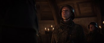 Movie still from “Indiana Jones and the Dial of Destiny” (2023), directed by James Mangold – A man wearing a helmet and a camouflage jacket; Close Up shot, Over the shoulder angle