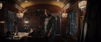 Movie still from “Indiana Jones and the Dial of Destiny” (2023), directed by James Mangold – A man in a uniform standing in a room; Medium shot, Low angle