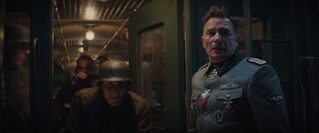 Movie still from “Indiana Jones and the Dial of Destiny” (2023), directed by James Mangold – A man in a military uniform standing next to another man in a military uniform; Medium shot, Over the shoulder angle