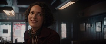 Movie still from “Indiana Jones and the Dial of Destiny” (2023), directed by James Mangold – A woman in a brown jacket smiling for the camera; Close Up shot, Over the shoulder angle