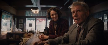 Movie still from “Indiana Jones and the Dial of Destiny” (2023), directed by James Mangold – A woman and an older man sitting at a bar; Medium shot, Over the shoulder angle