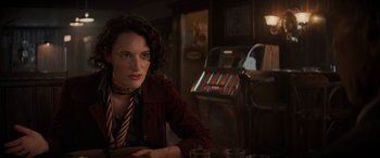 Movie still from “Indiana Jones and the Dial of Destiny” (2023), directed by James Mangold – A woman sitting at a table in front of a jukebox; Close Up shot, Over the shoulder angle