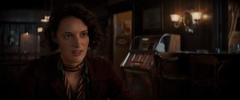 Movie still from “Indiana Jones and the Dial of Destiny” (2023), directed by James Mangold – A woman in a red jacket is in front of an old jukebox; Close Up shot, Over the shoulder angle