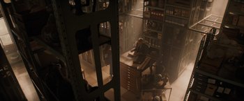 Movie still from “Indiana Jones and the Dial of Destiny” (2023), directed by James Mangold – A group of people sitting at a desk in a room; Wide shot, High angle