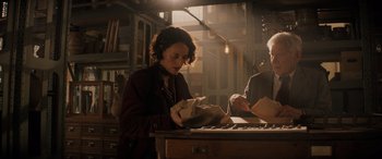 Movie still from “Indiana Jones and the Dial of Destiny” (2023), directed by James Mangold – A woman holding a bag in a room; Medium shot, Low angle