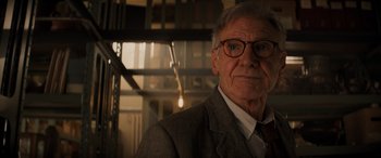 Movie still from “Indiana Jones and the Dial of Destiny” (2023), directed by James Mangold – An older man wearing glasses and a suit and tie; Close Up shot, Low angle