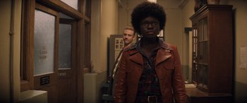 Movie still from “Indiana Jones and the Dial of Destiny” (2023), directed by James Mangold – A man and a woman standing next to each other in a hallway; Medium shot, Over the shoulder angle