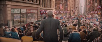 Movie still from “Indiana Jones and the Dial of Destiny” (2023), directed by James Mangold – An old man is standing in the middle of a crowd of people; Wide shot, High angle