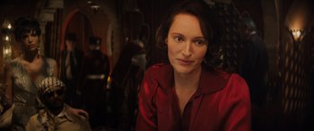 Movie still from “Indiana Jones and the Dial of Destiny” (2023), directed by James Mangold – A woman in a red shirt is looking at the camera; Close Up shot, Over the shoulder angle