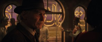 Movie still from “Indiana Jones and the Dial of Destiny” (2023), directed by James Mangold – A person wearing a hat; Close Up shot, Over the shoulder angle