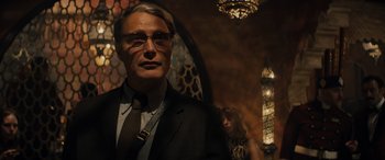 Movie still from “Indiana Jones and the Dial of Destiny” (2023), directed by James Mangold – A man in a suit and tie standing next to a woman in a dress; Medium shot, Low angle