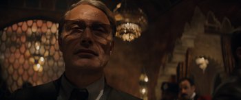 Movie still from “Indiana Jones and the Dial of Destiny” (2023), directed by James Mangold – An older man wearing glasses and a suit; Close Up shot, Low angle