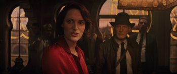 Movie still from “Indiana Jones and the Dial of Destiny” (2023), directed by James Mangold – A woman in a red shirt and a man in a black hat; Close Up shot, Over the shoulder angle