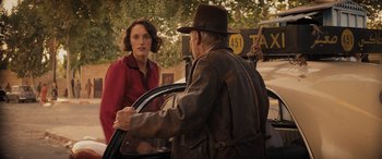 Movie still from “Indiana Jones and the Dial of Destiny” (2023), directed by James Mangold – An older man in a hat is talking to an older woman; Medium shot, Over the shoulder angle