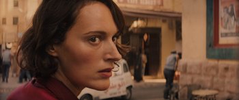 Movie still from “Indiana Jones and the Dial of Destiny” (2023), directed by James Mangold – A person's face on the side of the street; Close Up shot, Over the shoulder angle