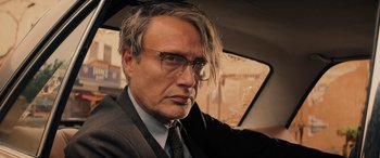 Movie still from “Indiana Jones and the Dial of Destiny” (2023), directed by James Mangold – A person in a car wearing glasses; Close Up shot, Over the shoulder angle