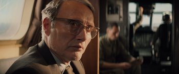 Movie still from “Indiana Jones and the Dial of Destiny” (2023), directed by James Mangold – An older man wearing glasses looking at the camera; Close Up shot, Over the shoulder angle