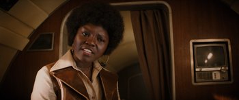 Movie still from “Indiana Jones and the Dial of Destiny” (2023), directed by James Mangold – A black woman with a large afro looking at the camera; Close Up shot, Over the shoulder angle